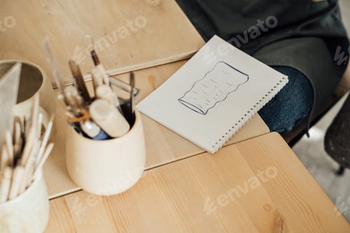 Preview: On the table in front of the girl lies a piece of paper with a painted vase