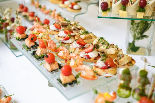 Preview: Catering. Off-site food. Buffet table with various canapes, sandwiches, hamburgers and snacks.
