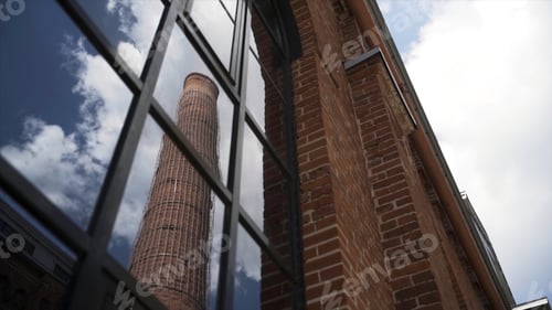 Preview: Old chimney of Moscow Arma business quarter reflected in a window. Action. Bottom view of a red