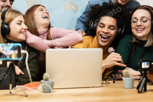 Preview: Multiracial friends streaming online using mobile phone and laptop computer