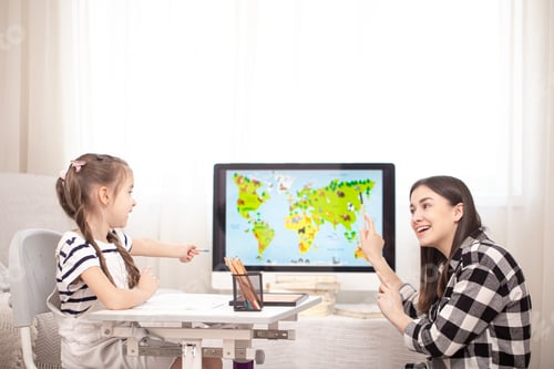 Preview: A mother with a child sits at the table and does homework. The child learns at home. Home schooling.