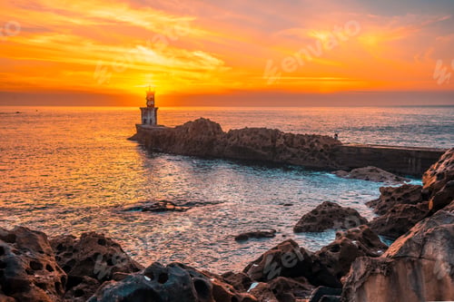 Preview: Detail of the sun behind the lighthouse at sunset in the town of Pasajes San Juan