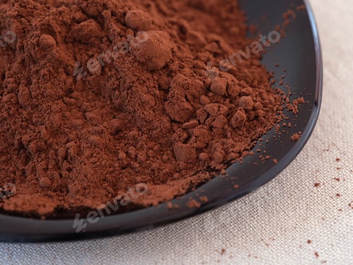 Preview: A black plate with organic cocoa powder in it