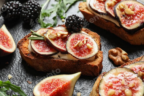 Preview: Bruschettas with cream cheese, figs and blackberries on slate plate, closeup