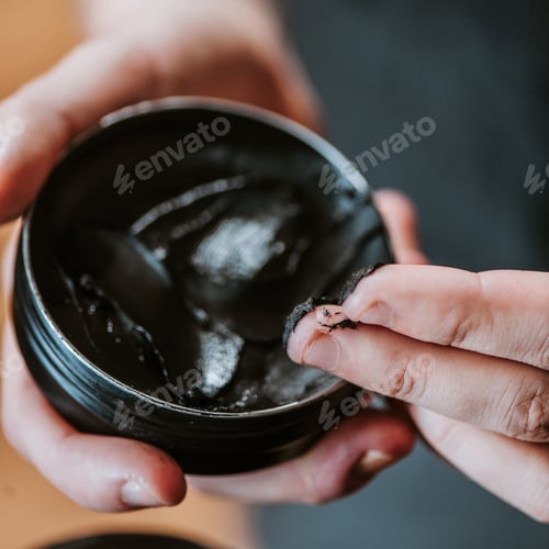 Preview: close up of barber holding jar with black hair pomade