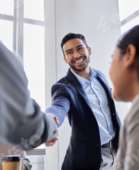 Preview: Smiling Man Handshaking in Bright Office Setting