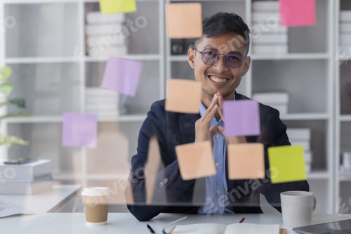 Preview: Concentrated adult business asian man, organizing his busy work week in the office. documents money