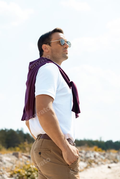 Preview: side view of pensive man in sunglasses looking away with cloudy sky on background
