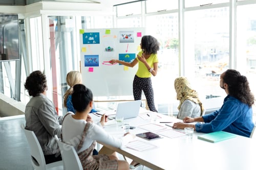 Preview: African-american businesswoman giving presentation on flip chart during meeting