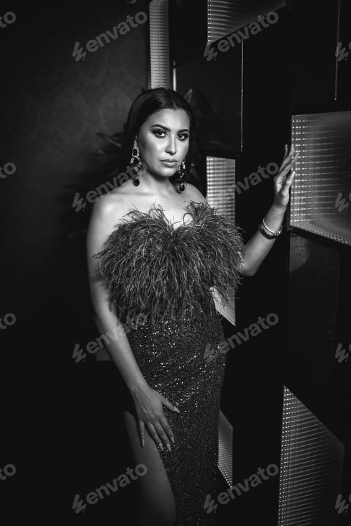 Preview: Grayscale shot of a young Caucasian female wearing a beautiful elegant dress at a restaurant