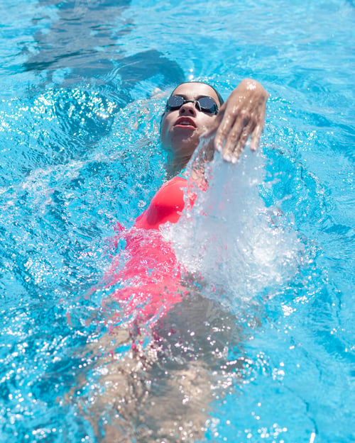 Preview: pro female swimmer swimming in sportive pool
