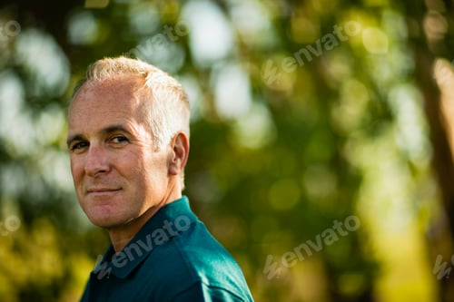 Preview: A mature man wearing a green shirt, in woodland.