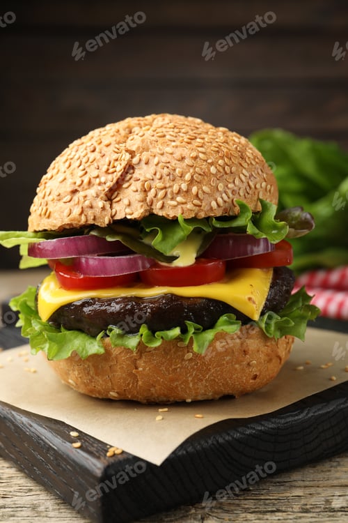 Preview: Delicious hamburger with patty and cheese on wooden table, closeup