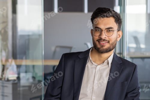 Preview: Confident Latin American businessman wearing glasses in a professional office setting