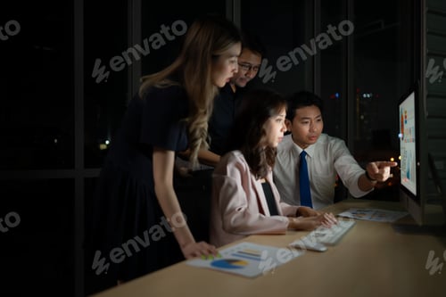 Preview: Group of business people working in office at night. Business concept.