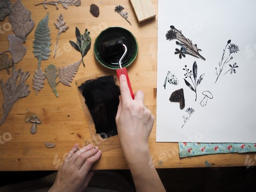 Preview: Linocut artist at work in art studio, top view.