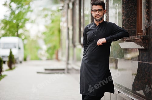 Preview: Pakistano bangladesh man wear black traditional clothes and eyeglasses pose outdoor.