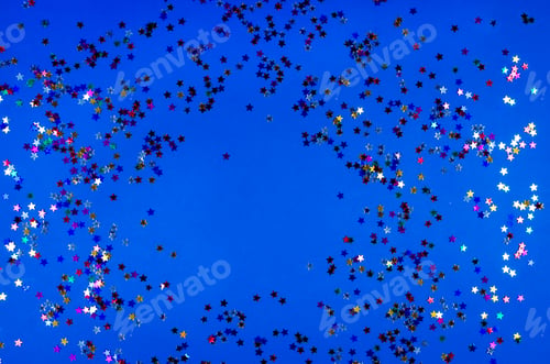 Preview: Shining little colorful stars on blue background.