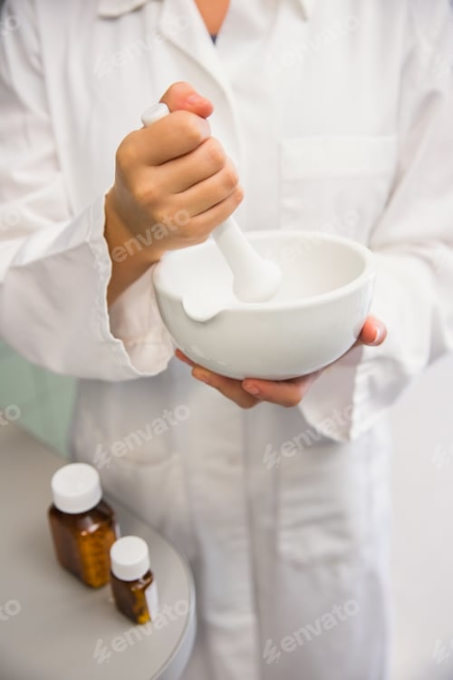 Preview: Junior pharmacist mixing a medicine at the hospital pharmacy