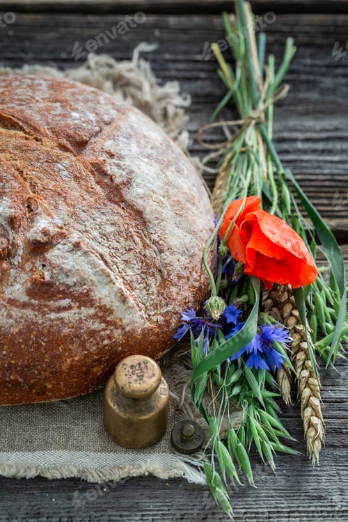 Preview: Homemade bread with wheat, ears and poppies on wooden table