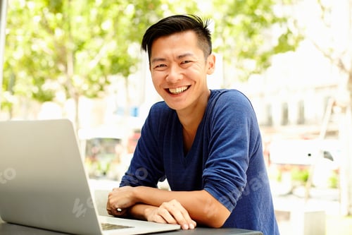 Preview: Portrait of male tourist using laptop at sidewalk cafe, The Bund, Shanghai, China