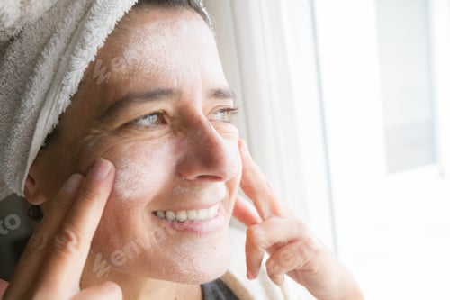 Preview: Closeup of the woman using the face cream. Face and body care with creams.