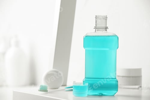 Preview: Bottle of mouthwash on white shelf in bathroom, space for text