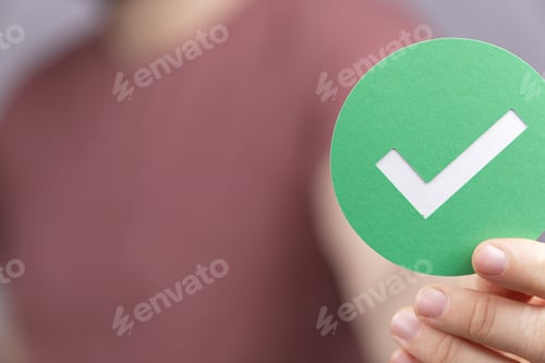 Preview: Man wearing a red shirt and holding a green sign with a tick