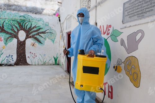 Preview: An Indian sanitary worker in a protective suit conducting disinfection of a school during COVID-19