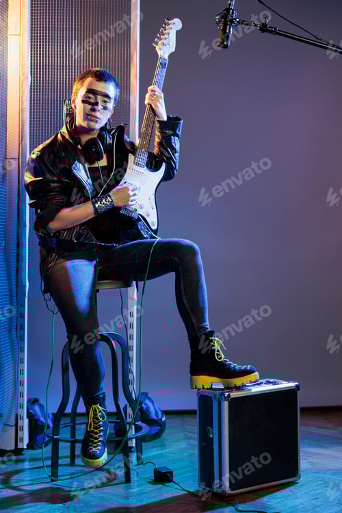 Preview: Rock singer sitting down and playing guitar