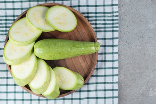 Preview: A dark board with sliced zucchini vegetables
