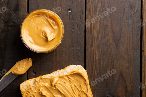 Preview: Image of bowl and bread slice with peanut butter on wooden surface