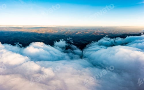 Preview: Thick layer of white clouds above mountains at sunrise