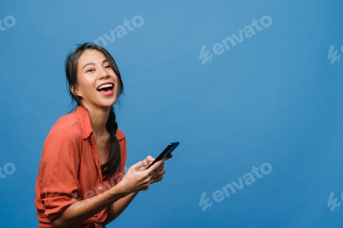 Preview: Surprised young Asia lady using mobile phone with positive expression.