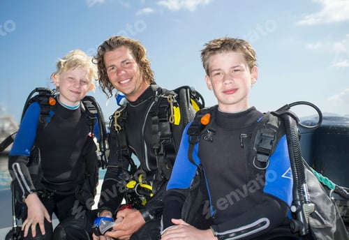 Preview: Portrait of two boys with mid adult male scuba diving teacher