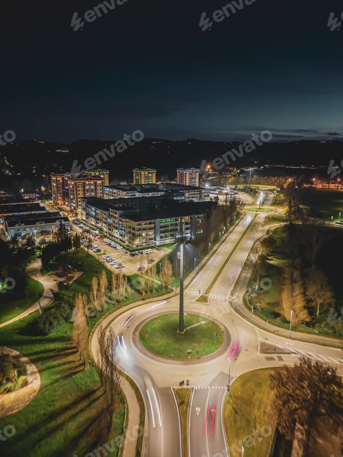 Preview: Aerial view of a road busy with cars regulated by a roundabout at night