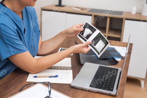 Preview: doctor interprets ultrasound results, making notes on her laptop for detailed documentation.