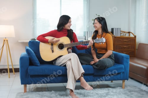Vista previa: Two young women playing acoustic guitar and singing at home