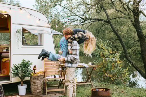 Preview: Young Couple Celebrating Outdoors Next To Travel Trailer