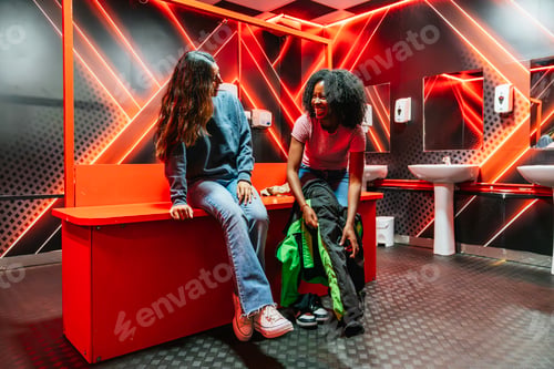 Preview: Women friends laughing changing into racing suits