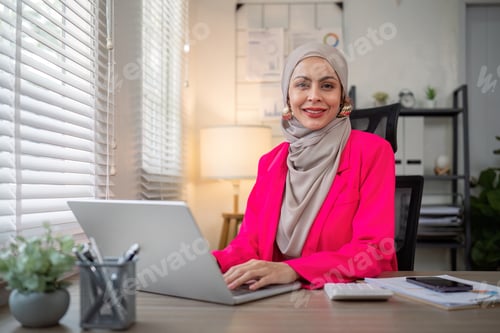 Preview: Muslim business woman hijab working about financial with business report and calculator on laptop