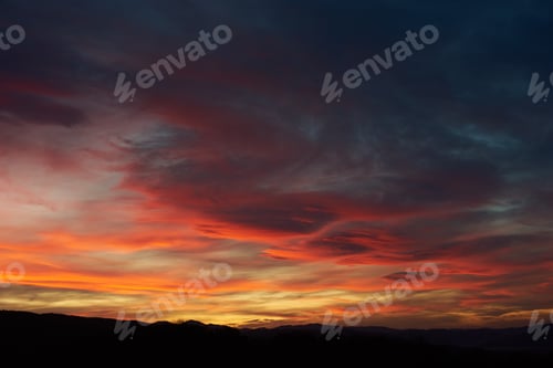 Preview: Stunning sunset paints sky with hues of red, orange, and pink, blending into deep blues and purples.