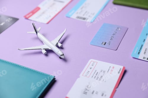 Preview: Airplane model, passport, credit card and flight tickets on violet background, closeup
