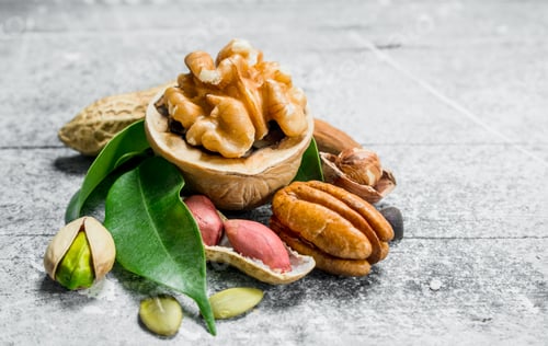 Preview: Various nuts with green leaves.