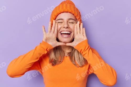 Preview: Horizontal shot of cheerful millennial girl keeps hands near opened mouth whispers good news keeps e