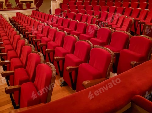 Preview: Close-up of traditional, classic empty chairs upholstered in red velvet, the interior of the theater