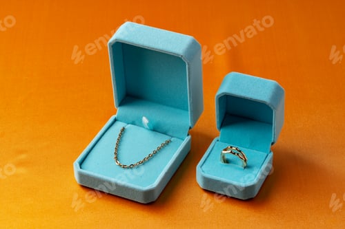 Preview: Blue boxes with golden jewelry on orange background