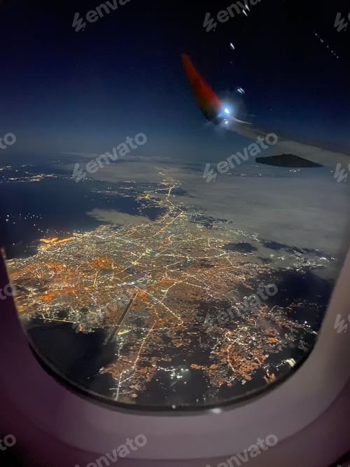 Preview: City view at night from inside an airplane