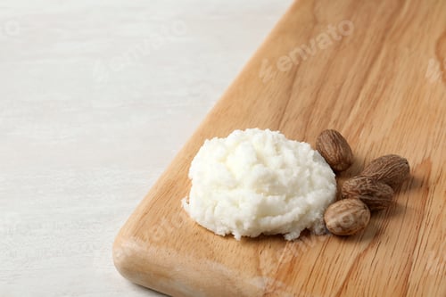 Preview: Shea butter and nuts on wooden board. Space for text