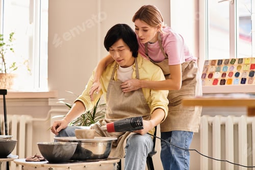 Preview: Young couple enjoys pottery making together in a cozy art studio filled with inspiration